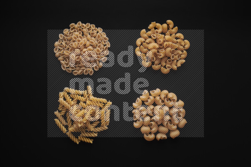 Different pasta types in bunches on black background