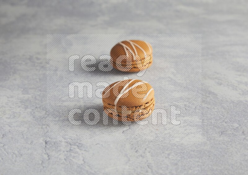 45º Shot of two Brown Irish Cream macarons  on white  marble background