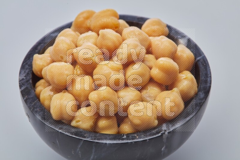Close up shot of boiled chickpeas in a container on white background