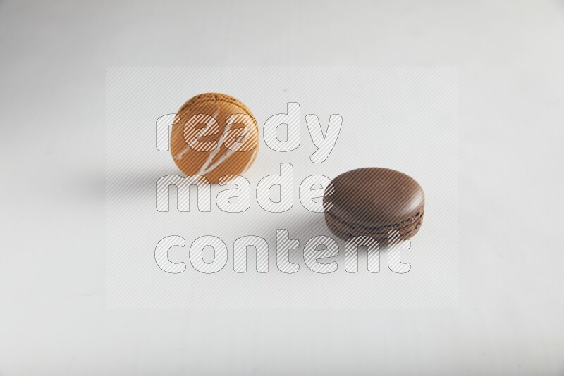 45º Shot of of two assorted Brown Irish Cream, and Brown Dark Chocolate macarons on white background