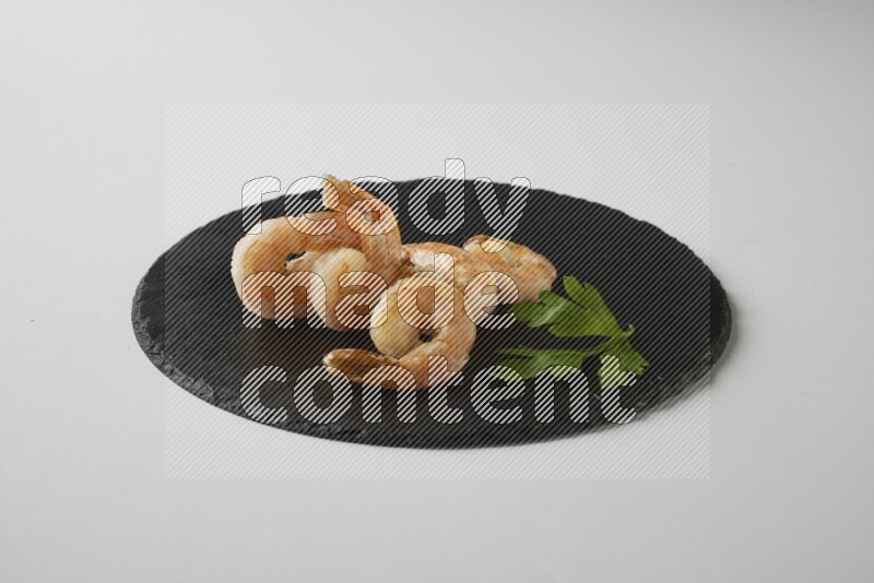 five grilled shrimps  on a black slate direct  on a white back ground