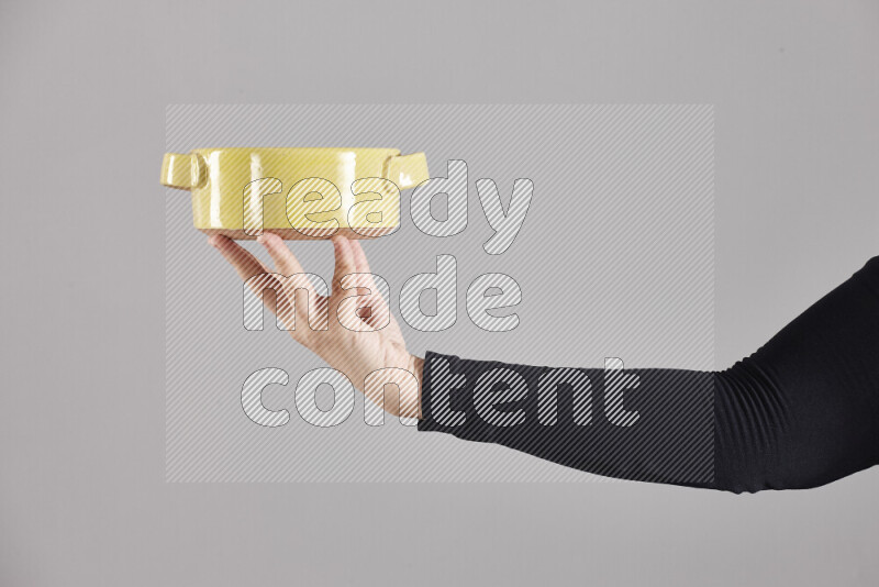 A woman in black abaya holding different pottery essentials in different positions