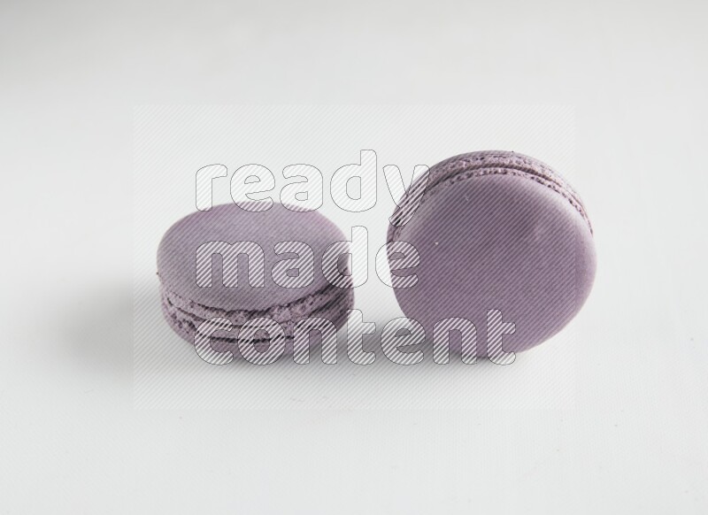 45º Shot of two Purple Blueberry macarons on white background