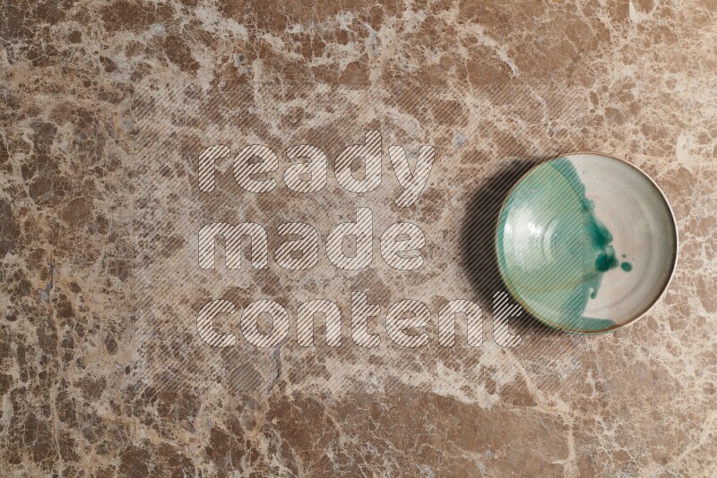 A decorative pottery plate on beige marble background
