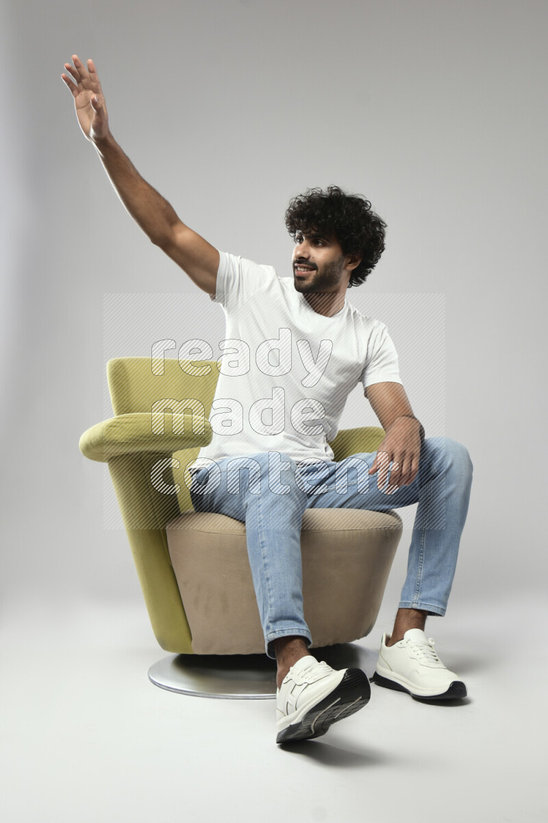 A man wearing casual sitting on a chair making a hand gesture on white background