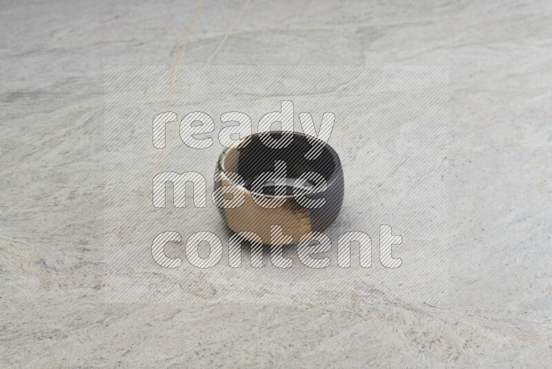 A multicolored pottery bowl on grey marble background