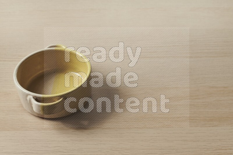 A multicolored pottery bowl on light wooden background