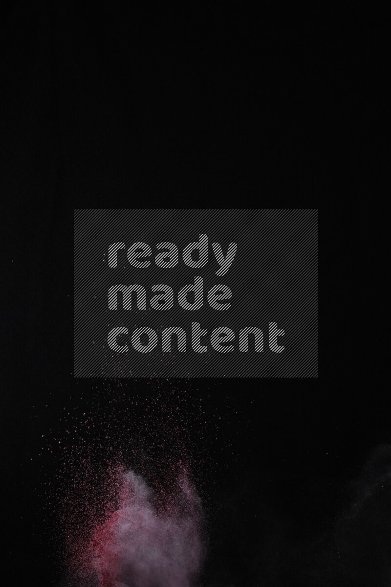 A side view of red powder explosion on black background