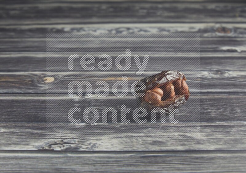 hazelnut stuffed madjoul date on a wooden grey background