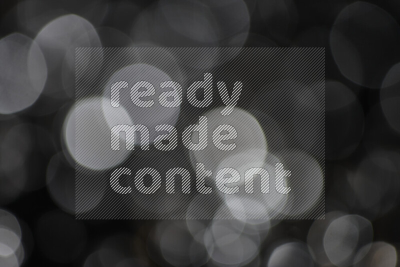 Silver shimmering fragments of glass scattered on a black background