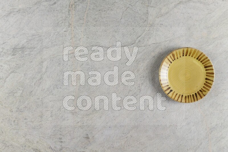 A multicolored pottery plate on grey marble background