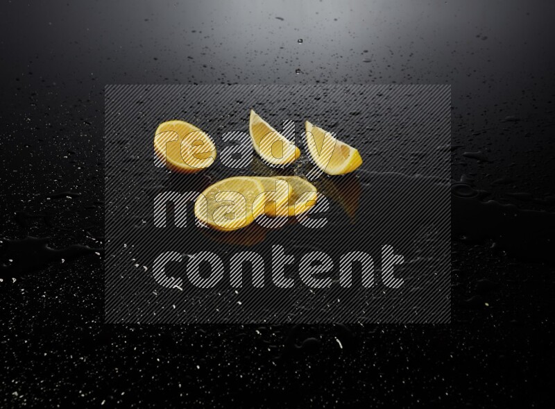 Lemon slices with water drops, and droplets on black background
