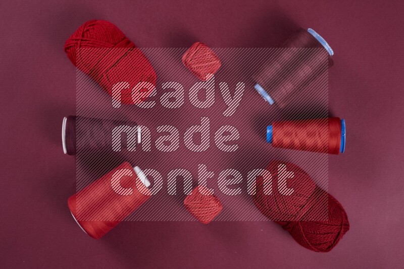 A red collection of sewing and tailoring tools arranged on a red background