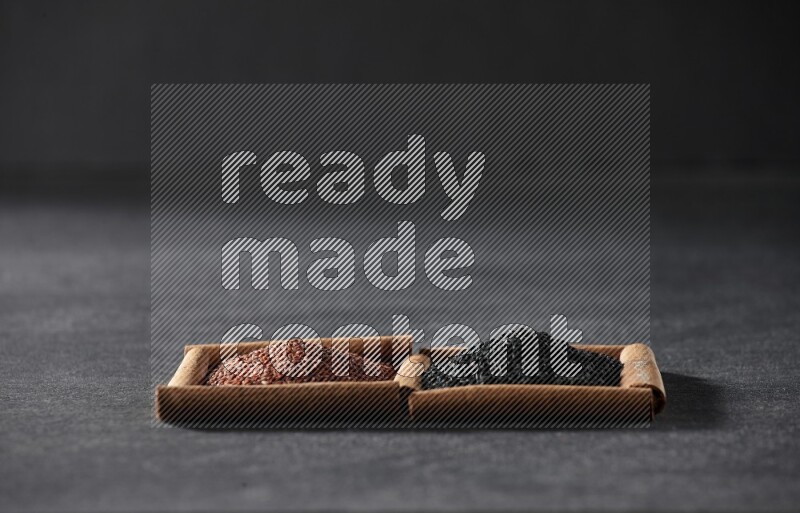 مربعان من أعواد القرفة ممتلئان بحب الرشاد وحبة البركة السوداء علي خلفية سوداء