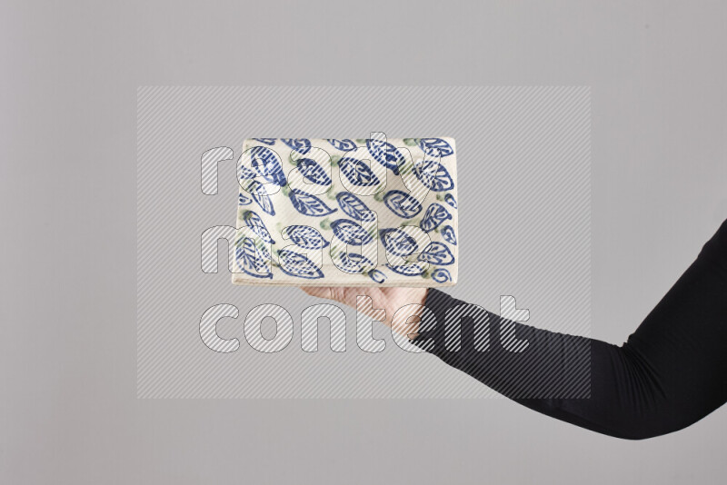 A woman in black abaya holding different pottery essentials in different positions