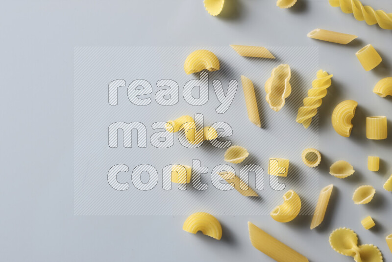 Different pasta types on light blue background