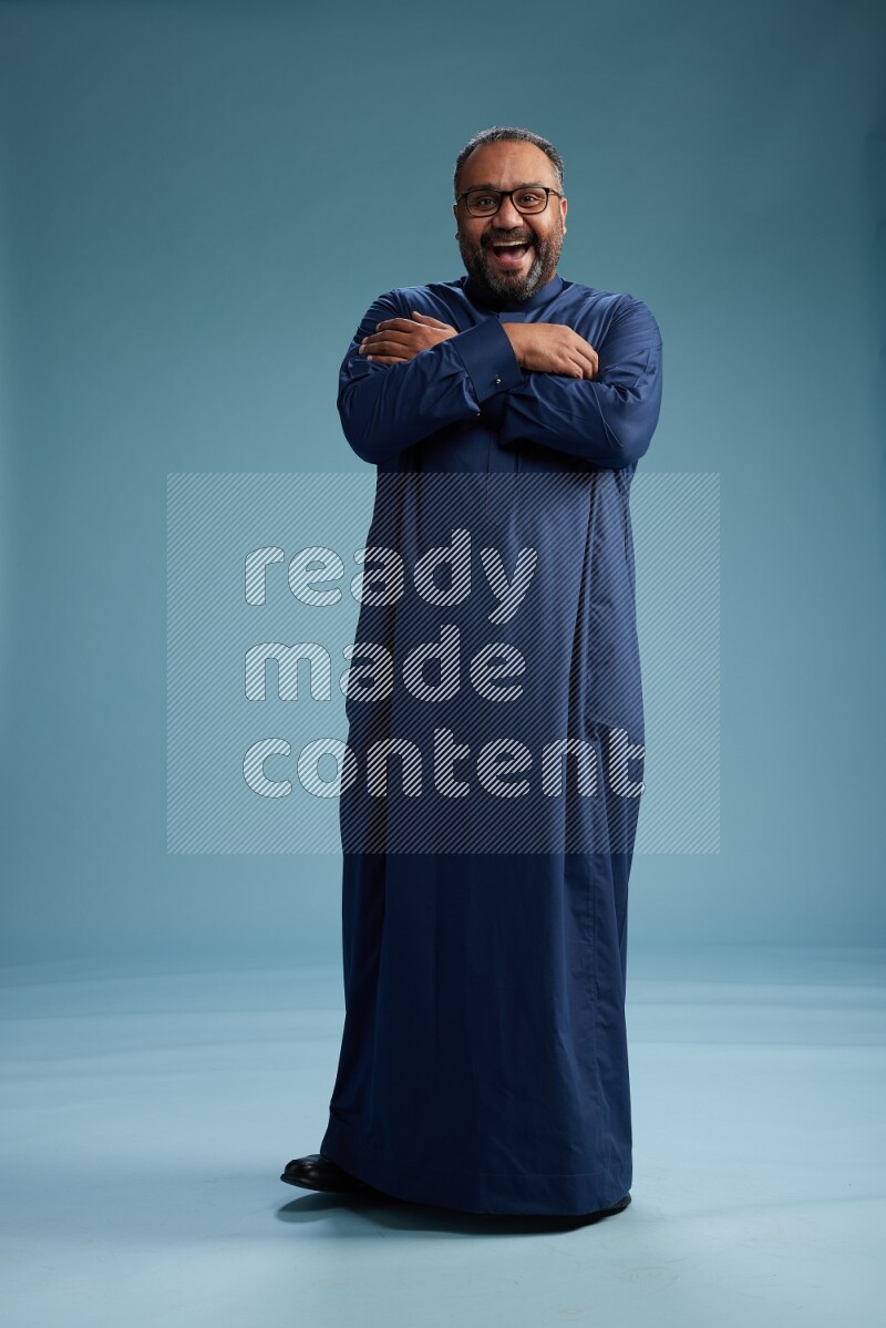 Saudi Man without shimag Standing Interacting with the camera on blue background
