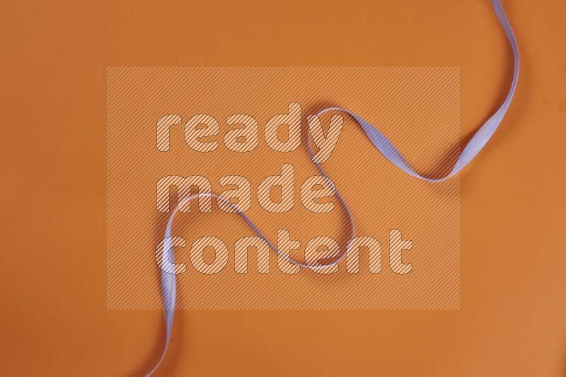 مجموعة من أدوات الخياطة والتفصيل أرجوانية اللون على خلفية برتقالية