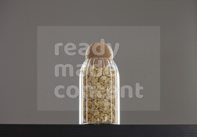 Crushed beans in a glass jar on black background