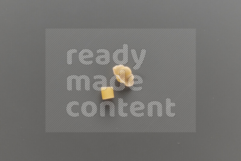 Big rings pasta with other types of pasta on grey background