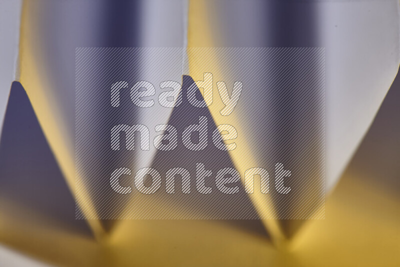 صورة مجردة مقربة تظهر طيات ورقية هندسية حادة بتدرجات اللون الأبيض مع درجات لونية دافئة