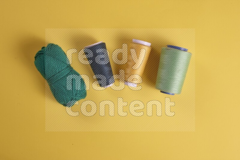 A green collection of sewing and tailoring tools arranged on a yellow background
