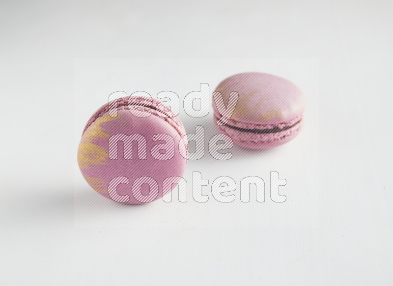 45º Shot of two Purple Strawberry macarons on white background