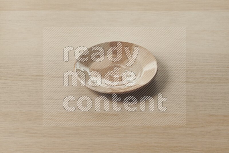 A multicolored pottery plate on light wooden background