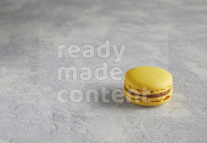 45º Shot of Yellow Lemon macaron on white  marble background