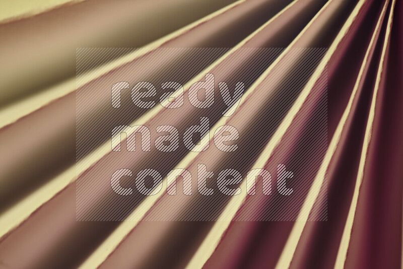An image presenting an abstract paper pattern of lines in red and gold tones