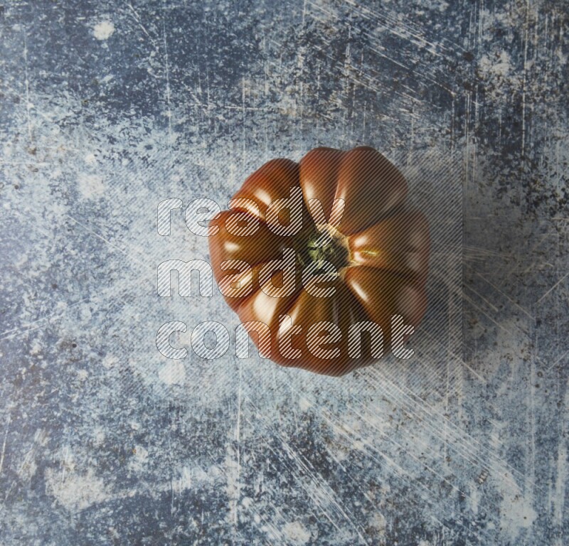 Single Topview Heirloom Tomato on a textured rustic blue background