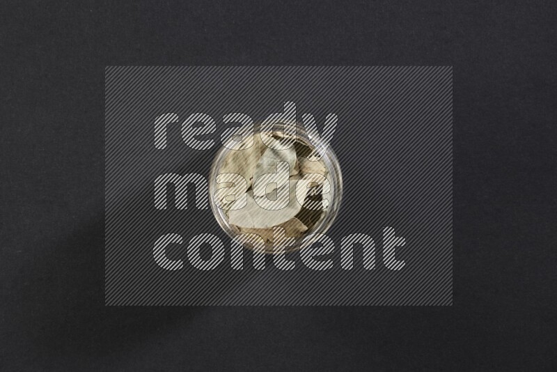 وعاء زجاجي ممتلئ بأوراق الغارعلي خلفية سوداء