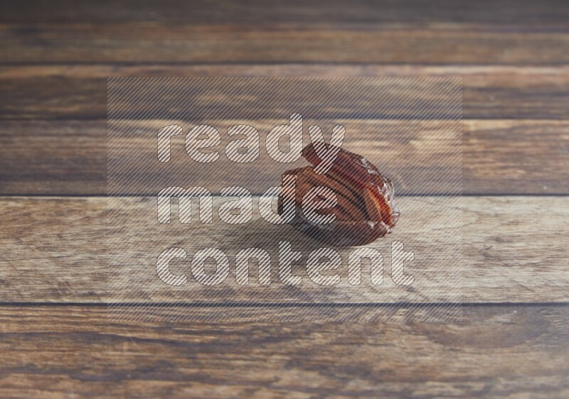 pecan stuffed madjoul date on a wooden background