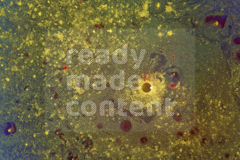 The image captures a dramatic splatter of yellow and red paints over an blue backdrop