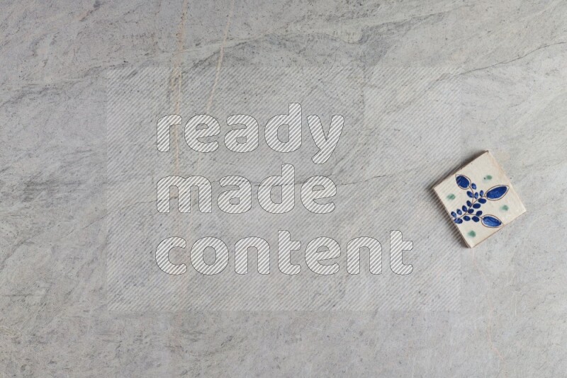 A decorative pottery coaster on grey marble background