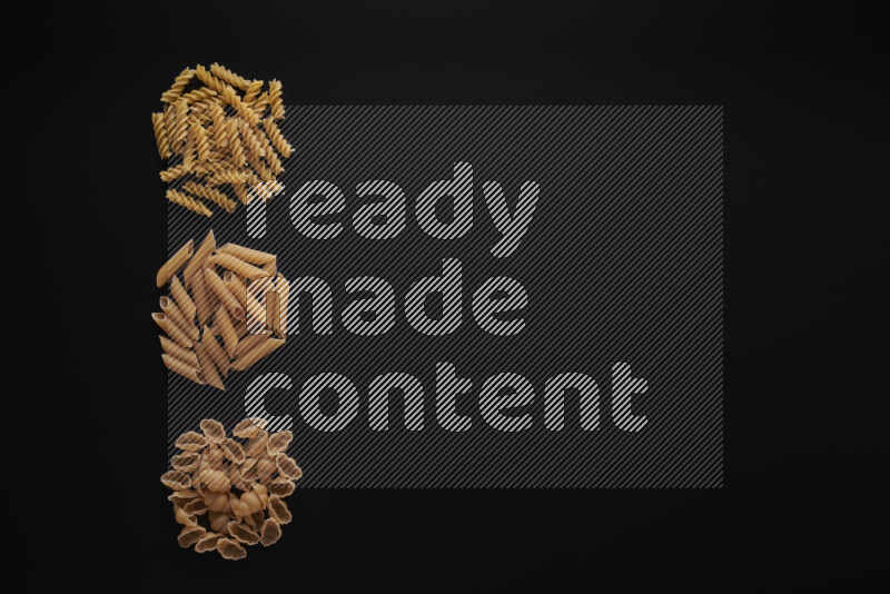 Different pasta types in 3 bunches on black background