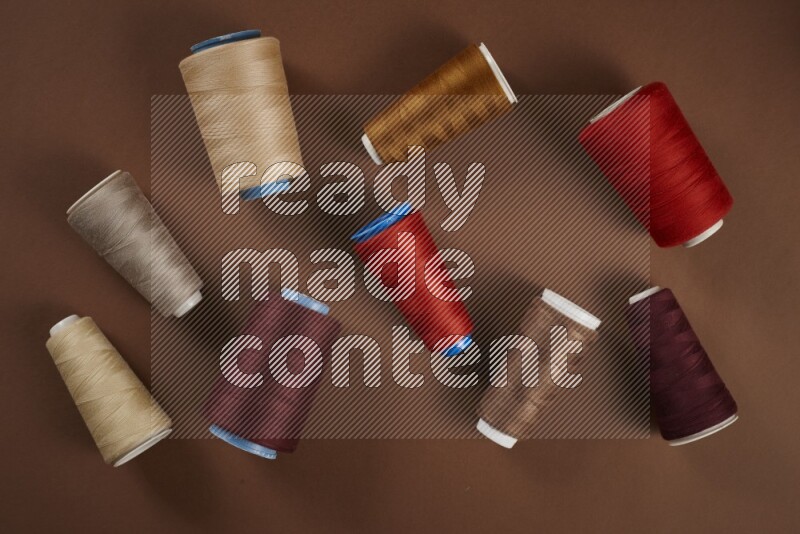 A red collection of sewing and tailoring tools arranged on a brown background