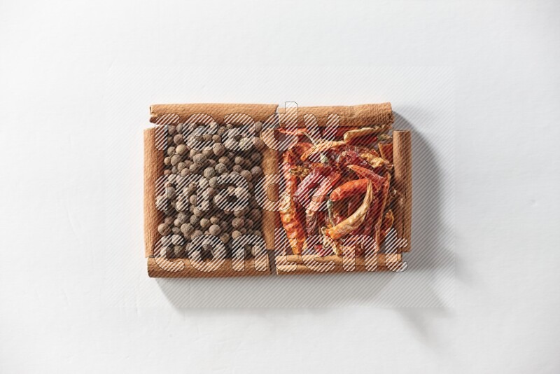 2 squares of cinnamon sticks full of dried red chilis and allspice on white flooring