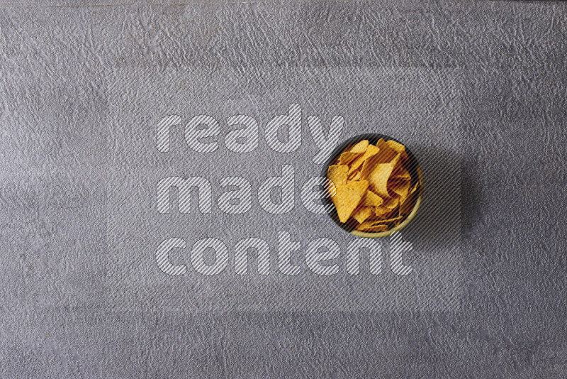 Assorted snacks in pottery bowls on grey background