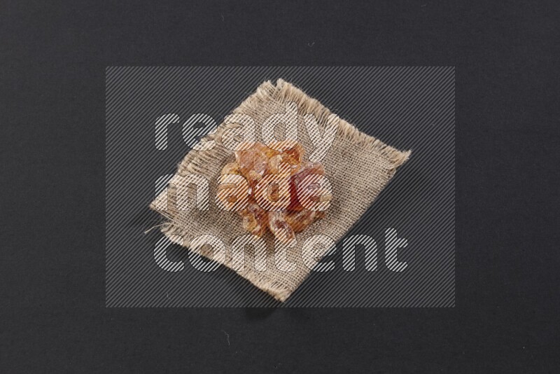 Gum arabic on a burlap piece on black flooring