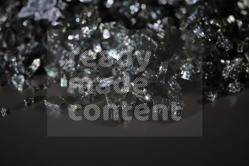 Transparent black fragments of glass scattered on a black background