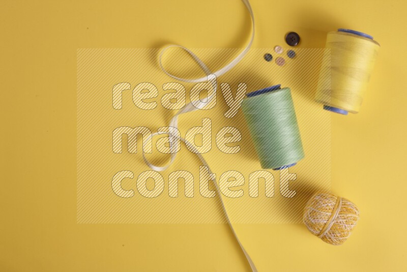 A green collection of sewing and tailoring tools arranged on a yellow background
