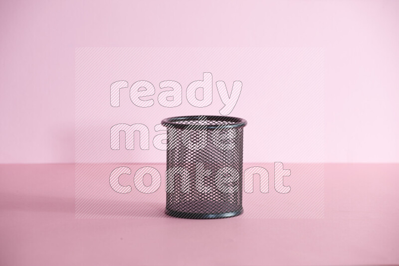 أقلام ومستلزمات مدرسية مختلفة أخري في حامل أقلام معدني على خلفية وردية