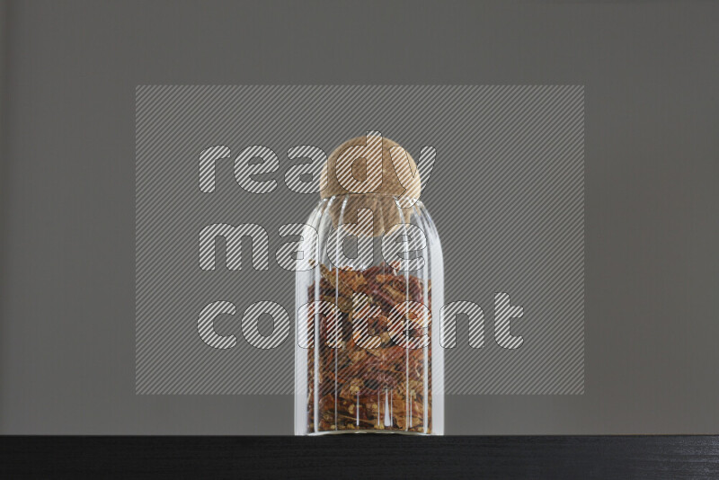 Chili pepper in a glass jar on black background
