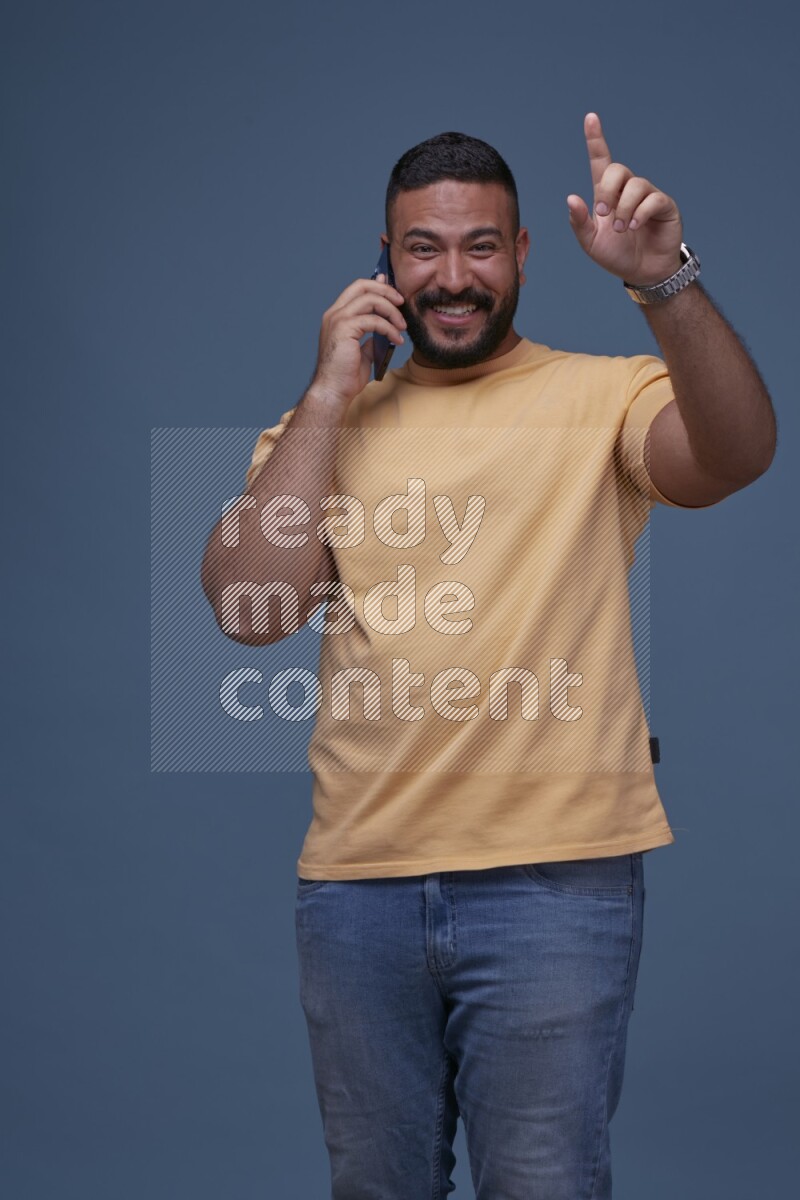 A man Calling on Blue Background wearing Orange T-shirt