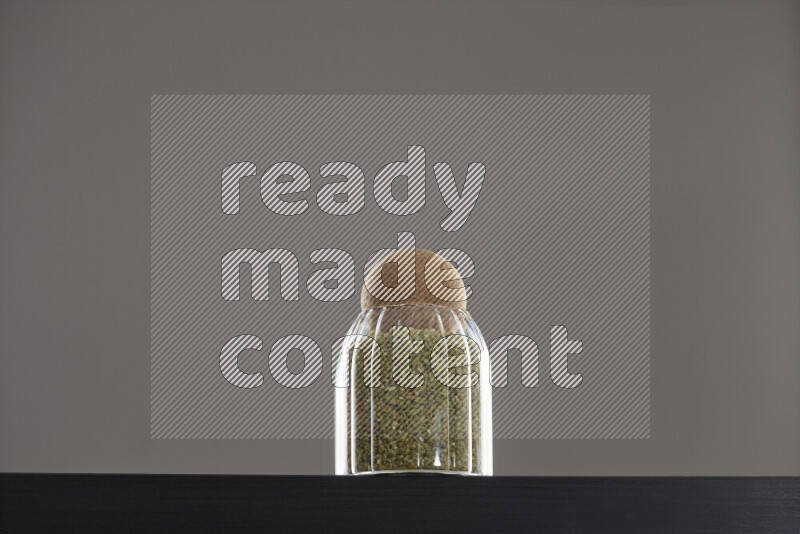 Freekeh in a glass jar on black background