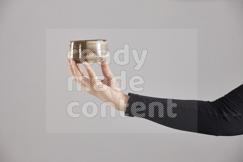 A woman in black abaya holding different pottery essentials in different positions