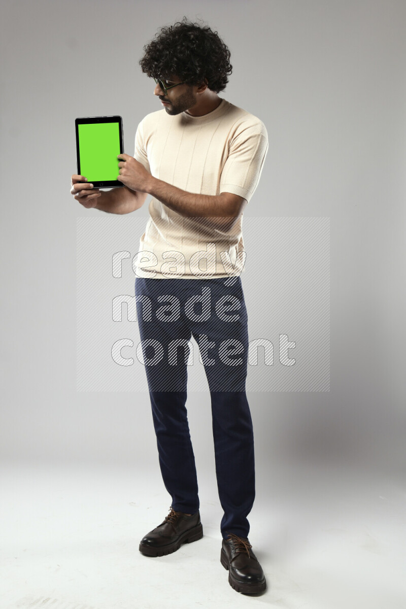A man wearing casual standing and showing a tablet screen on white background