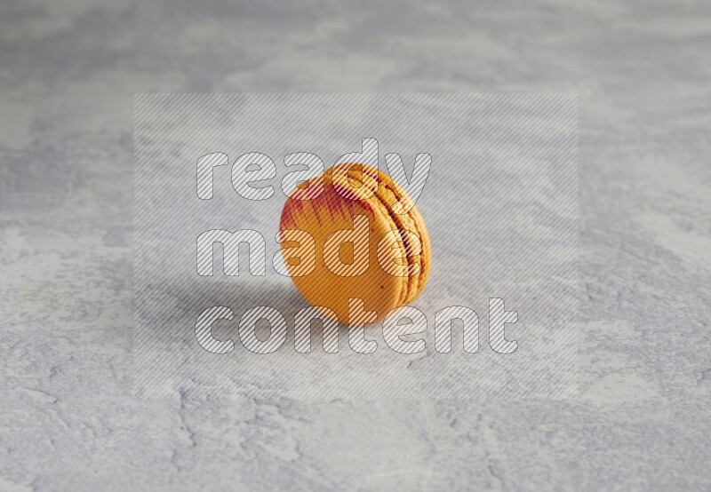 45º Shot of Orange Exotic macaron on white  marble background
