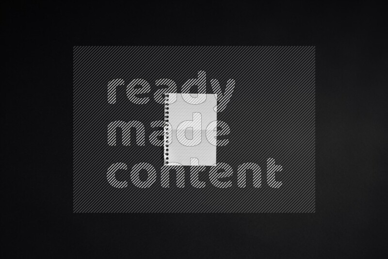 Folded notebook sheet on black background